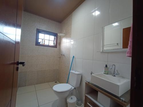 a bathroom with a toilet and a sink and a window at CHÁCARA BARBOSA II in Socorro