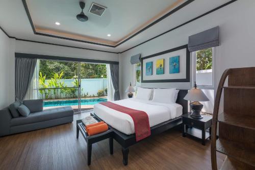 a bedroom with a large bed and a pool at Villa Sirion in Kamala Beach