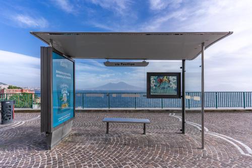 una fermata dell'autobus con una panchina sotto una tettoia di 1000 Suites a Napoli