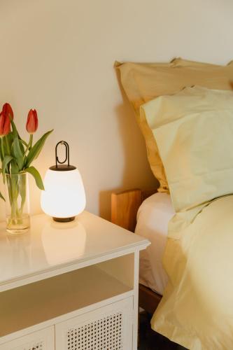 a table with a lamp and a vase with flowers on it at Buffalo Lodge in Coromandel Town