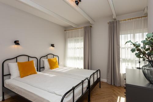 a bedroom with a bed with yellow pillows at Vaivutės Apartamentai No3 in Darbėnai