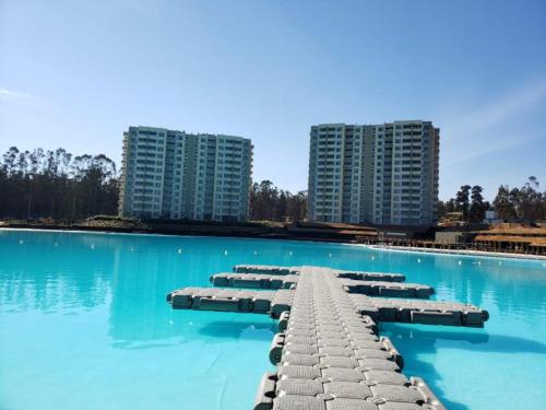 une grande piscine d'eau bleue et de grands bâtiments dans l'établissement Condominio Lagunamar, Las Cruces, à San Antonio