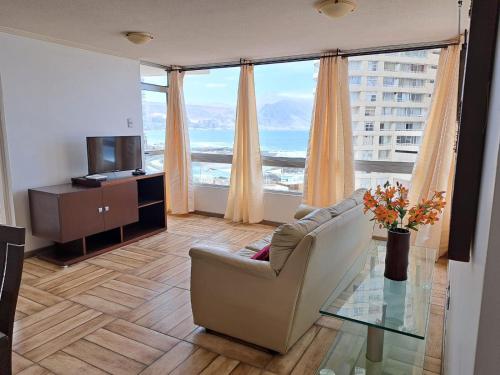a living room with a couch and a glass table at Naulitus Departamentos Vista Panorámica frente al Mar in Iquique
