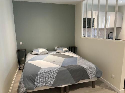 1 dormitorio con 1 cama con edredón blanco y negro en Cocon 2 calme en cœur historique en Périgueux