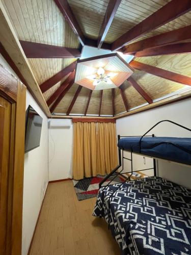 a room with a bed and a ceiling fan at Cabañas Los Olmos in San José de Maipo