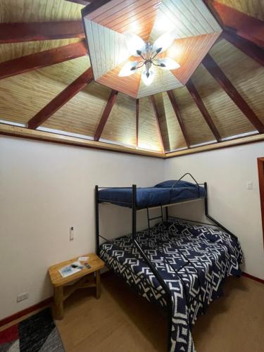 a bedroom with a ceiling fan and a bed at Cabañas Los Olmos in San José de Maipo