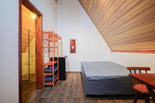 een slaapkamer met een bed en een ladder in een kamer bij Sítio Terra Sertaneja - Chalé Estou Apaixonado in Turvo dos Góis
