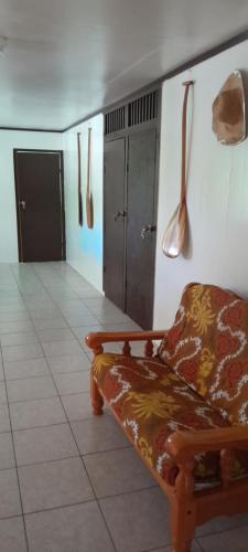 a living room with a couch and utensils on the wall at Penu Maurua 2 in Te-Fare-Arii