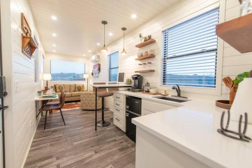 a kitchen with white countertops and a living room at New Southwest Shipping Container-In Alpine in Alpine