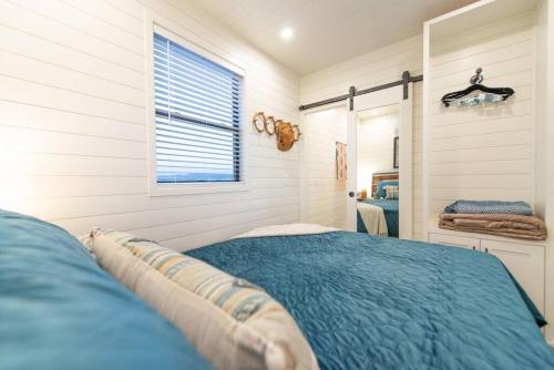 a bedroom with a blue bed and a mirror at New Southwest Shipping Container-In Alpine in Alpine