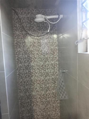 een badkamer met een douche met een douchekop bij Rhostel Boqueirão in Passo Fundo