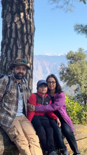 a man and a woman and a child sitting next to a tree at Ananta Prana in Mussoorie