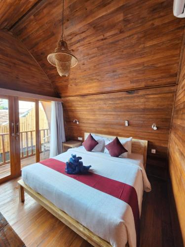 a bedroom with a large bed with wooden walls at Jineng Guest house by the swand in Dalung