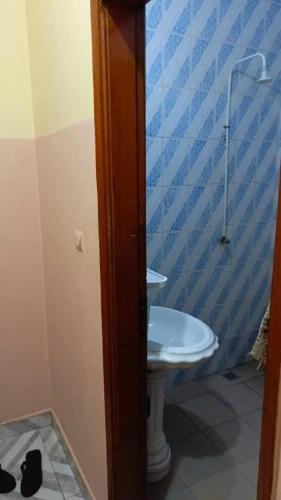 a bathroom with a white sink and a blue wall at Luxury House in Porto-Novo