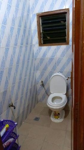 a bathroom with a toilet with blue and white walls at Luxury House in Porto-Novo