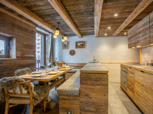 une salle à manger avec une table et des chaises en bois dans l'établissement Appartement de Prestige avec Cheminée au Centre de Val-d'Isère, à Proximité des Pistes et Commerces - FR-1-694-205, à Val dʼIsère