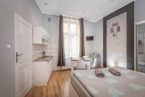 sypialnia z łóżkiem i stołem oraz kuchnia w obiekcie Queen Apartments w Krakowie