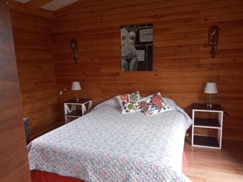 a bedroom with a bed and two tables with lamps at Casa Ayuntún in Puerto Montt