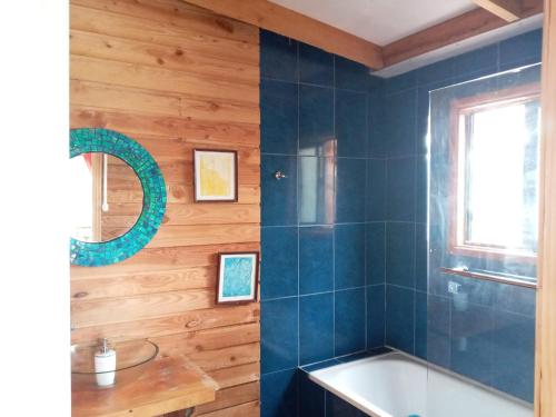 a bathroom with a tub and a sink and a mirror at Casa Ayuntún in Puerto Montt