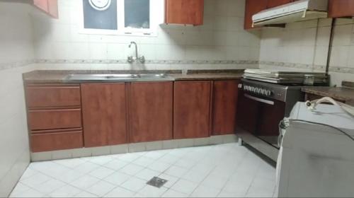 a kitchen with a sink and a stove at Partion Room Rental in Sharjah