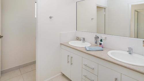 a bathroom with two sinks and a mirror at Hans Christian - A family acreage escape in Sarina