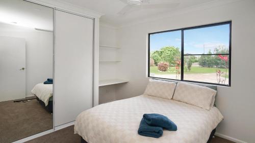 a bedroom with a bed and a large window at Hans Christian - A family acreage escape in Sarina