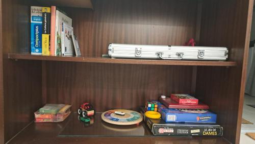 une étagère contenant des livres et des jouets dans l'établissement Studio maxi 3 pers, acces H24, proche gare pour Paris, à Sainte-Geneviève-des-Bois