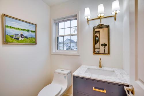 a bathroom with a white toilet and a sink at Airy West Cape May Cottage Less Than 1 Mi to Beach! in Cape May