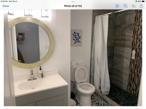 W łazience znajduje się umywalka, toaleta i lustro. w obiekcie Stylist bedroom central of Baltimore w mieście Baltimore