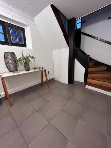 a living room with a bench and a staircase at De Blasis Budget Rooms in Santiago