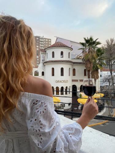 a woman holding up a glass of wine at De Blasis Budget Rooms in Santiago