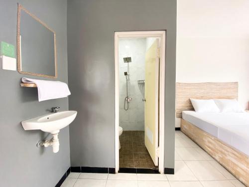 uma casa de banho com uma cama e um lavatório ao lado de um WC em Hotel Summer Of Surf em Ungasan