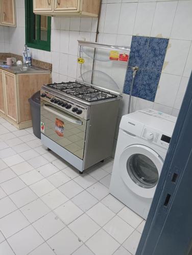 una cucina con piano cottura e lavatrice di Bedspce Available Sharjah a Sharjah