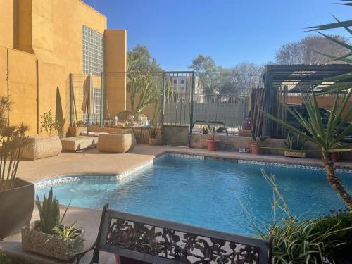 a swimming pool with a bench next to a building at Hotel Boutique Azhares in Copiapó