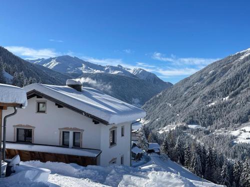 a house covered in snow with mountains in the background at Ferienhaus Wolf in Raut
