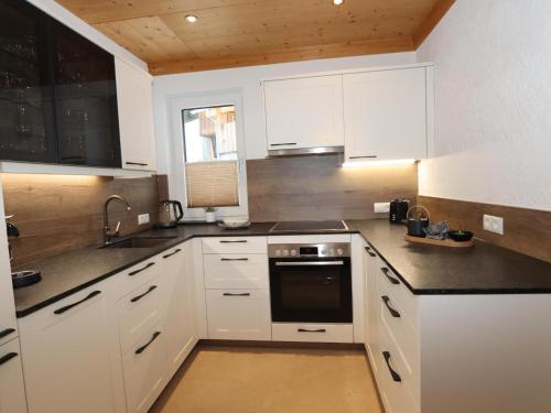 a kitchen with white cabinets and a stove top oven at Ferienhaus Wolf in Raut