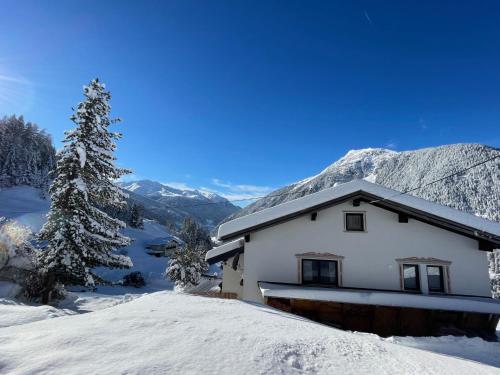 a house in the snow with mountains in the background at Ferienhaus Wolf in Raut