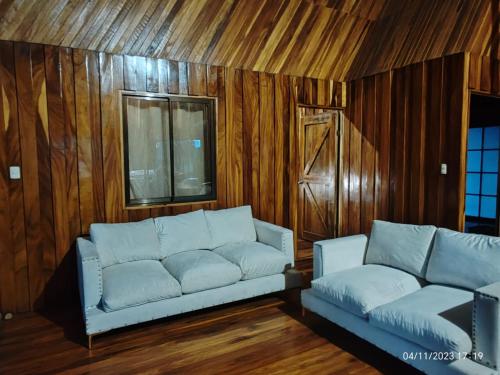 San RafaelにあるMy Country House Paradise, Rio Celeste!のソファ付きのリビングルーム、木製の壁