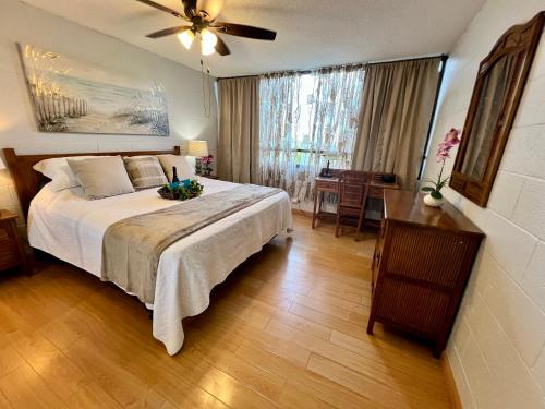 1 dormitorio con 1 cama grande y ventilador de techo en Direct Oceanfront Mauna Loa Shores Honu Elua #508 next to Carlsmith Beach park, Hilo HI, en Hilo