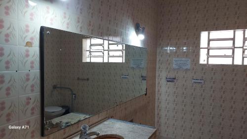 a bathroom with a large mirror and a sink at Casa de hóspedes 436 in Curitiba