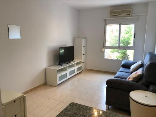 sala de estar con sofá y TV en Centrico Apartamento Nova Bega cerca del mar, en Cullera