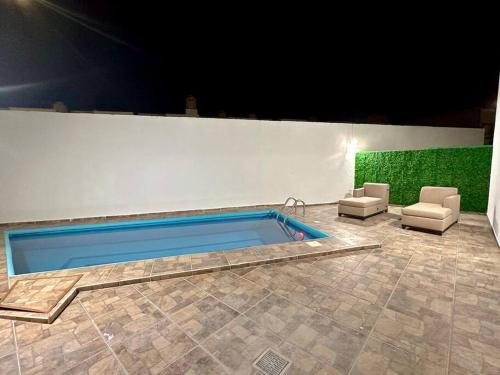 - une piscine avec 2 chaises et un canapé dans l'établissement Casa con Alberca Privada, à Aguascalientes