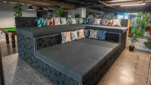 ein großes Sofa in einem Zimmer mit Tisch in der Unterkunft Mad Monkey Bayswater in Sydney