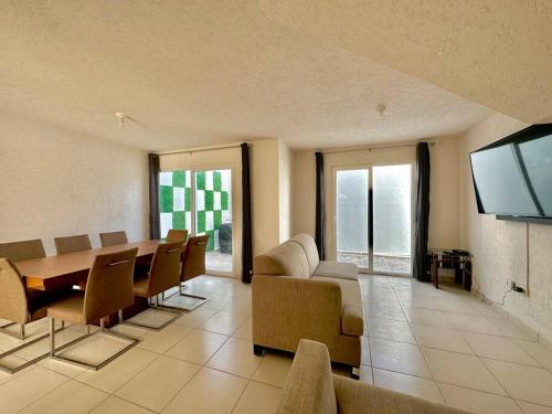 a living room with a table and chairs and a television at Casa con Alberca Privada in Aguascalientes