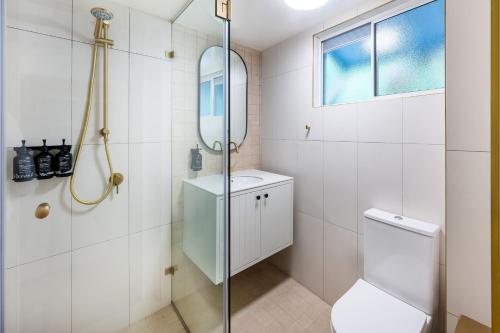 a bathroom with a toilet and a glass shower at Mantra Club Croc in Airlie Beach