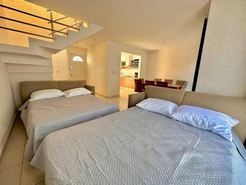 a bedroom with two beds and a dining room at Casa con Alberca Privada in Aguascalientes