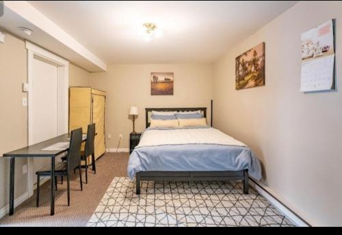 Schlafzimmer mit einem Bett, einem Schreibtisch und einem Tisch in der Unterkunft Triple K Cozy Private Suite in Portland Estate in Halifax