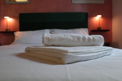 three towels are stacked on top of a bed at BELLEVUE APARTMENTS in SantʼAgata deʼ Goti