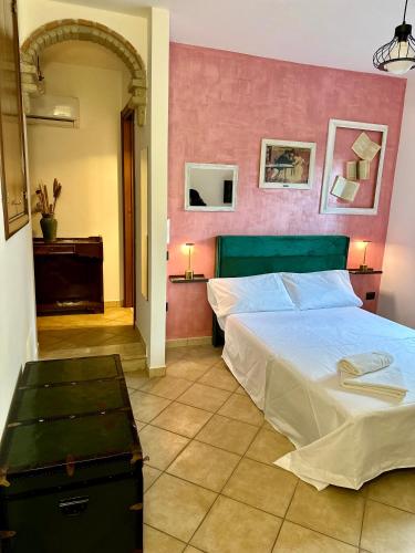 a bedroom with a bed and a pink wall at BELLEVUE APARTMENTS in SantʼAgata deʼ Goti