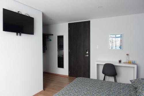 a bedroom with a bed and a black door at Maison Lapinou in Momoxpan